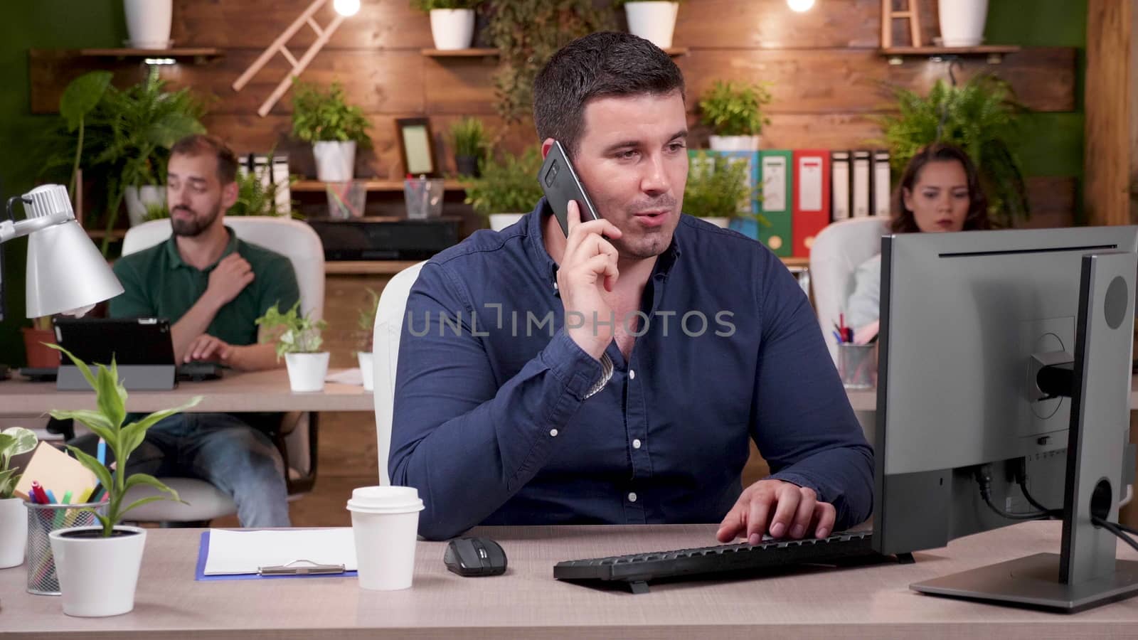 Office worker having a phone conversation in modern and cozy office. Slow motion shot