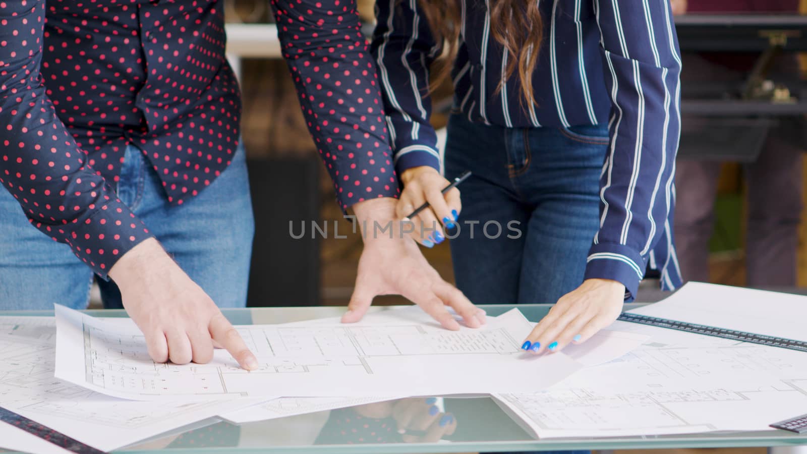 Professional architects drawing over blurprints, close up shot