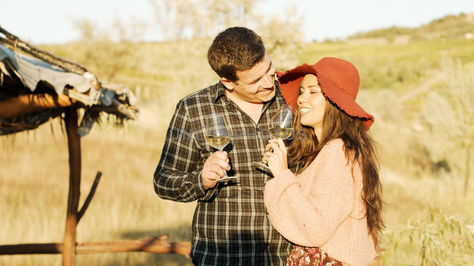Couple tasting white wine in warm sunlight.