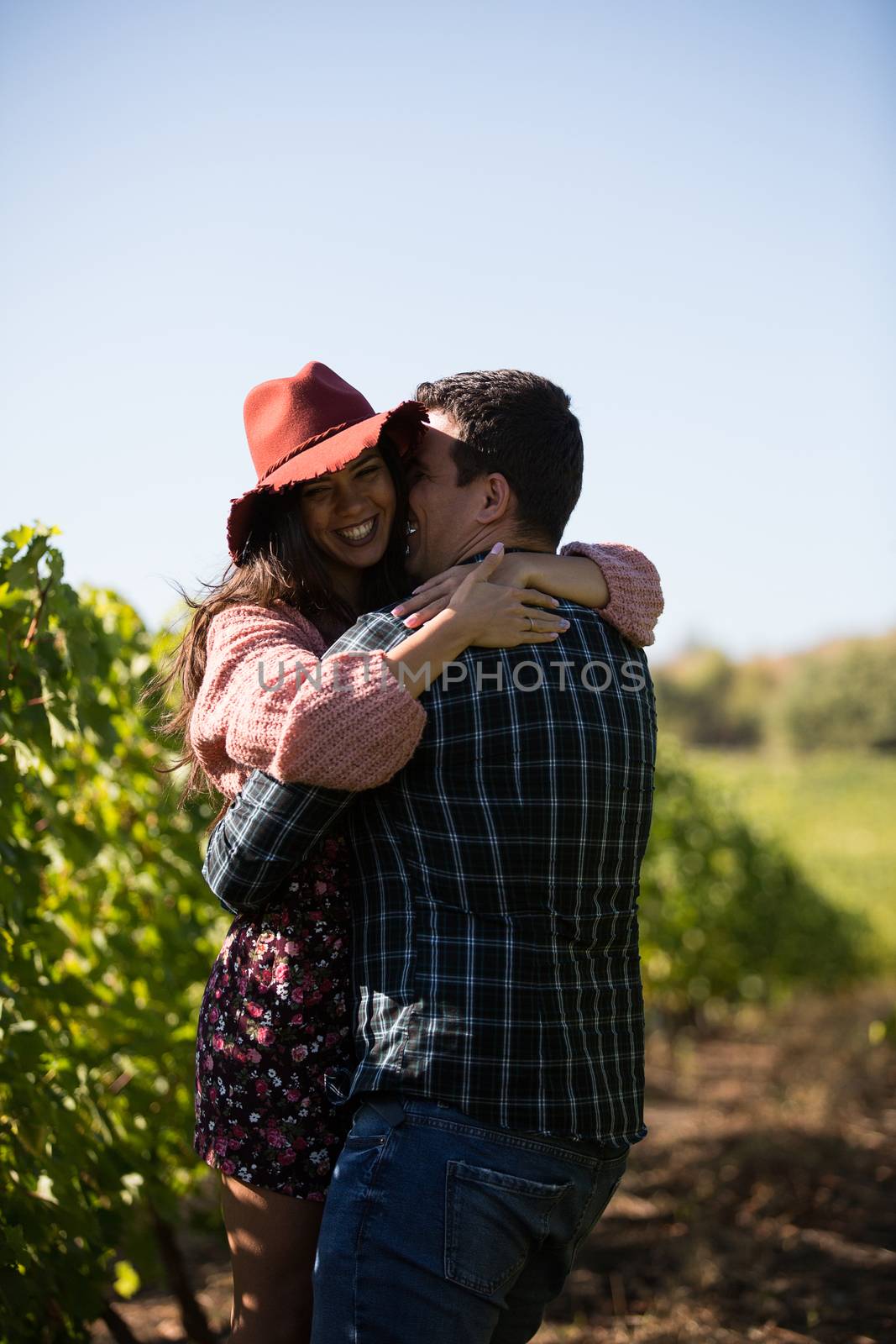 Romantic young man spinning her beautiful girlfriend in vinyard. Vinyard on the country side.