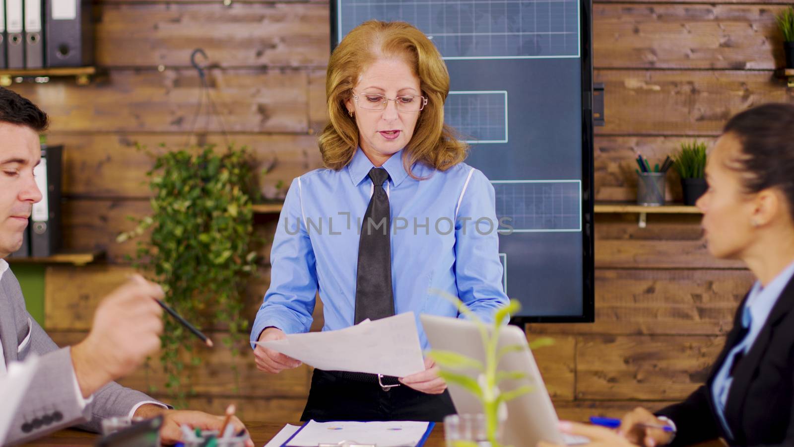Confident female director giving charts to new investors. Breaking annual revenue.