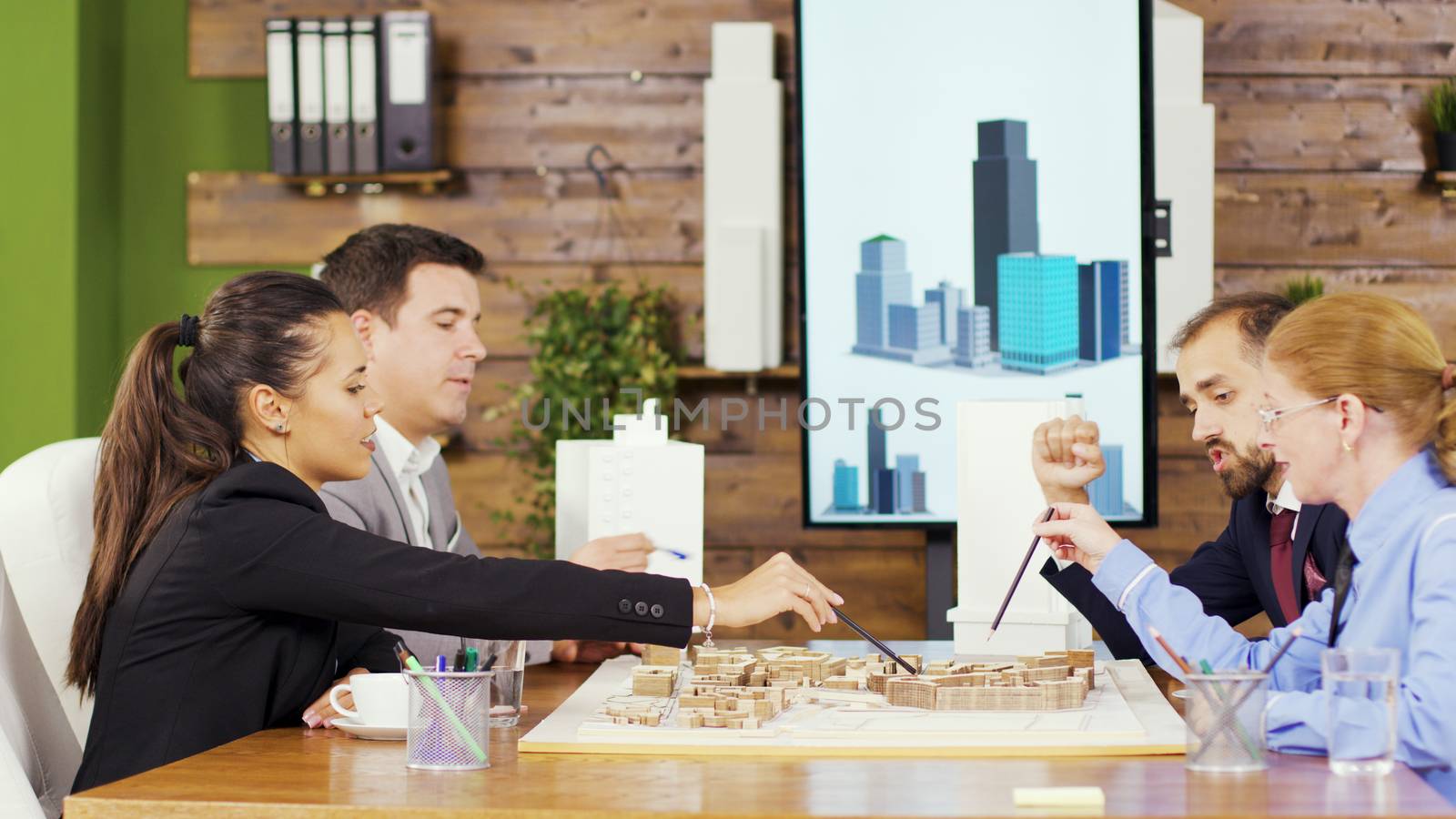 Team of creative architects in the conference room having a discussion about their new town project. Mini town.