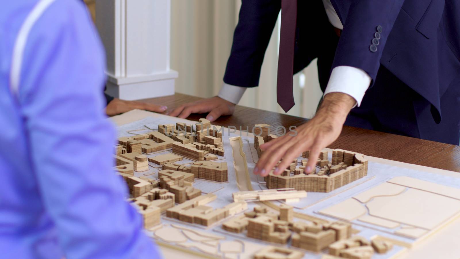 Young architect in business suit explaning his new construction project to a team of real estate investors in the conference room.