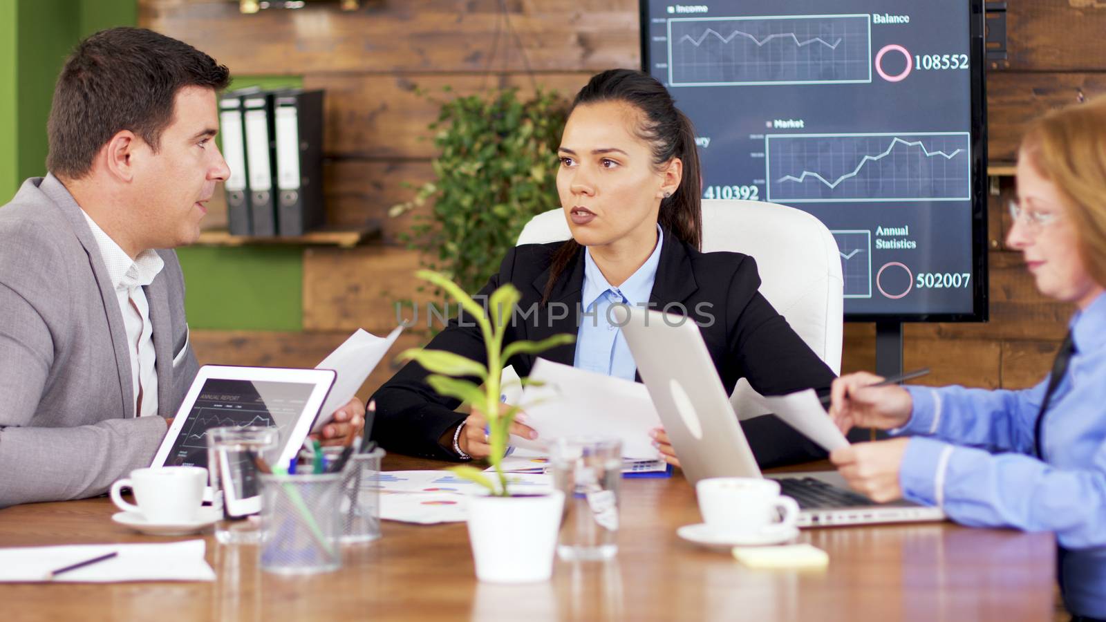 Female team leader giving his team financial charts. Female director having a discussion with her team.