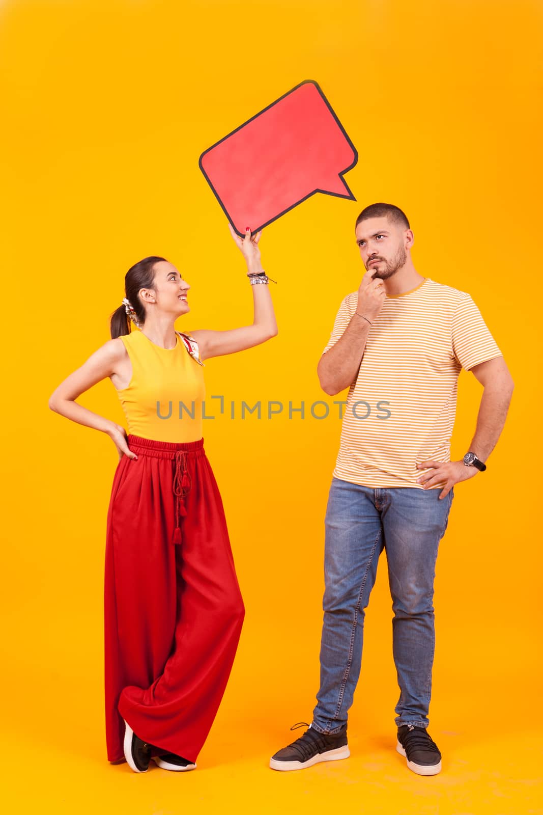 Smiling girlfriend holding empty bubble thought over thoughtful boyfriend. Copy space available.