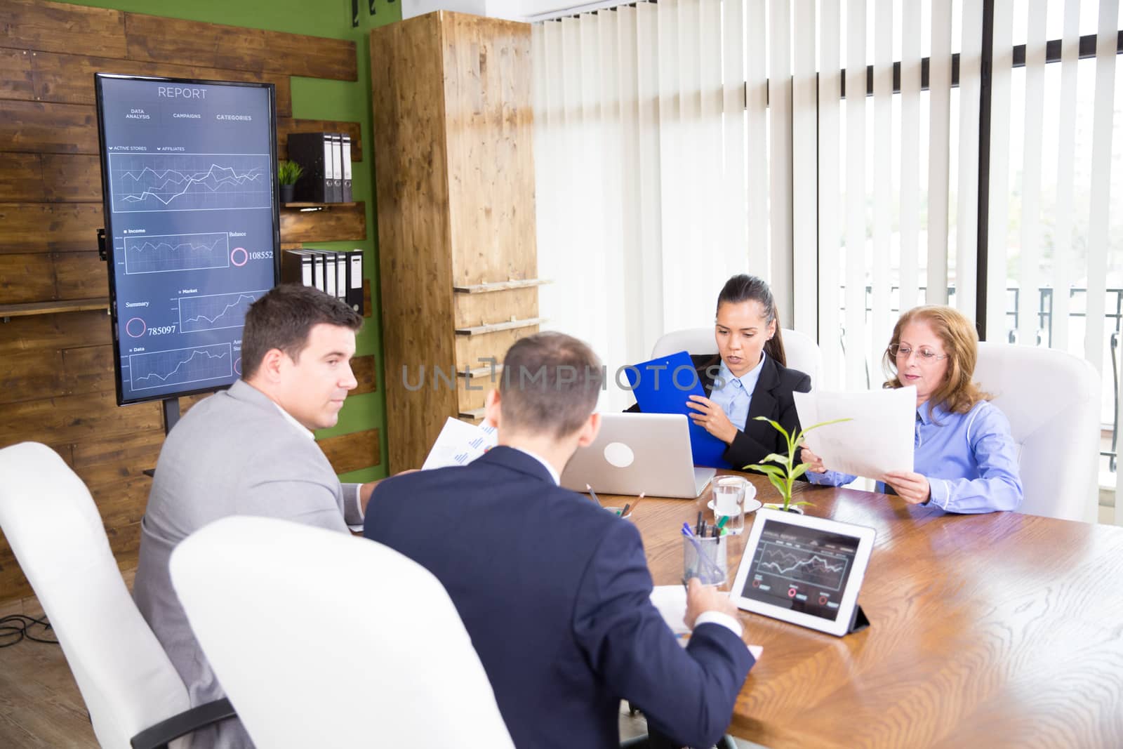 Adult people working productively on business project together in coference room.