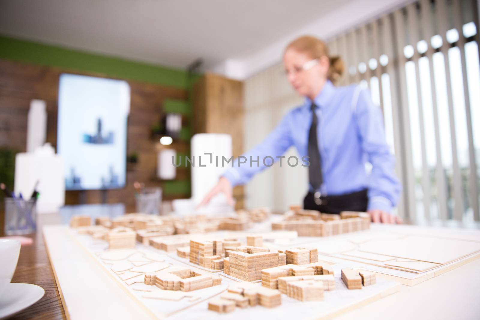 Close up of female architect working on real estate project. Mini town.