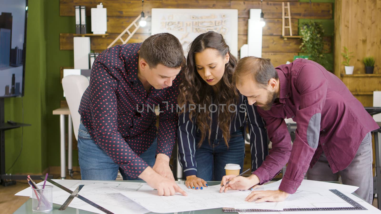 In modern and cozy office team of architects and designers are working on a new project