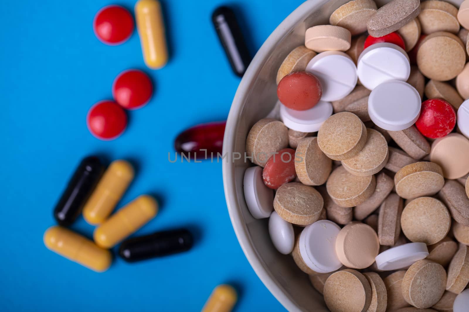 Close up with pills of different colors and shapes. Macro and red color