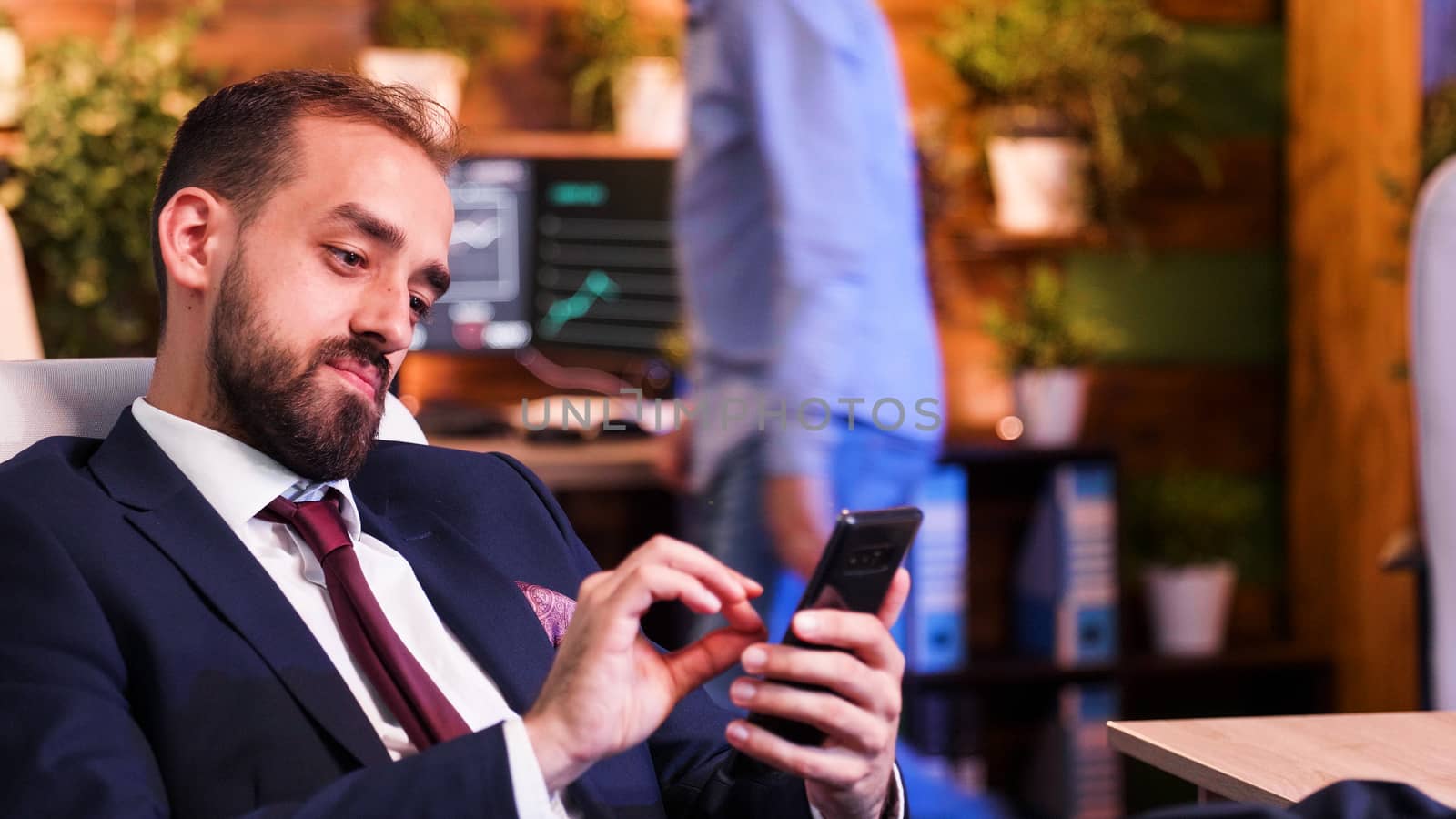 Close up of Businessman holding the phone in his hand. Modern office