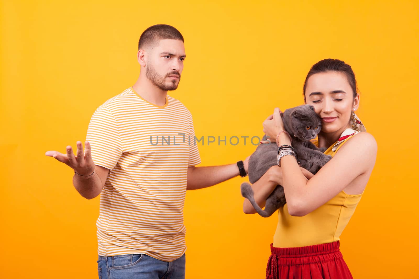 Gelous boyfriend on their cat for stealing affection from his girlfriend. Girl loving her cat.