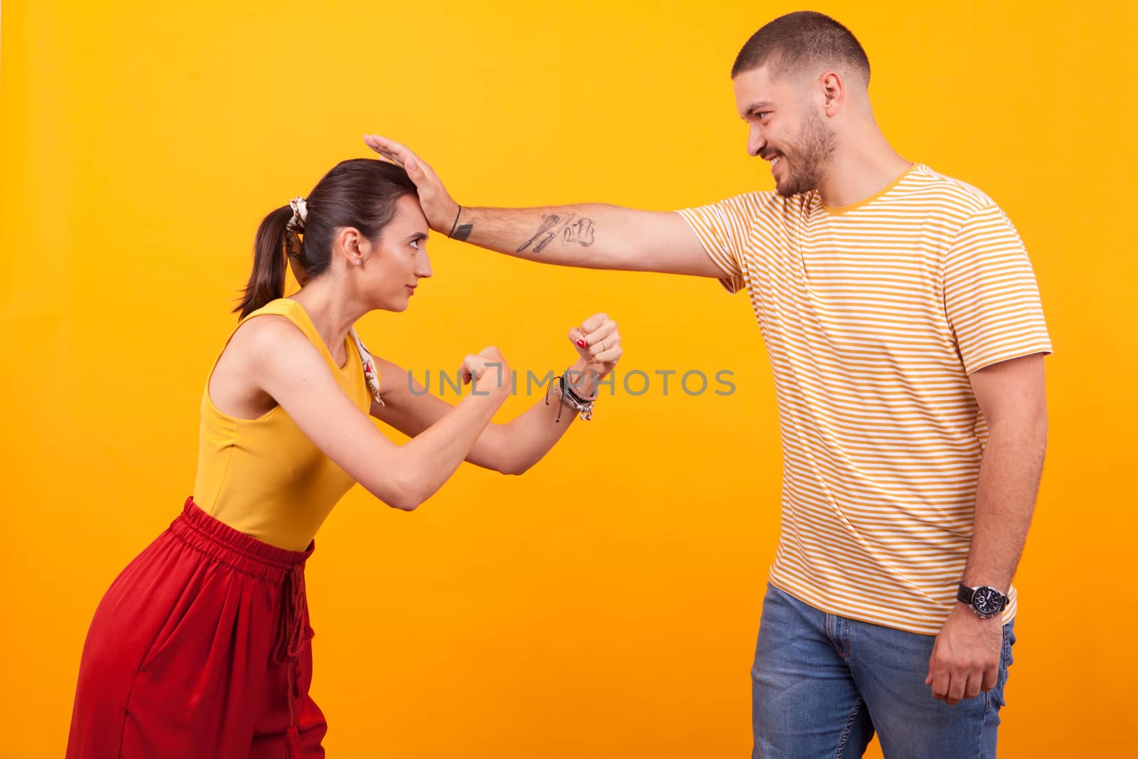 Cute couple having fun in a studio over yellow background