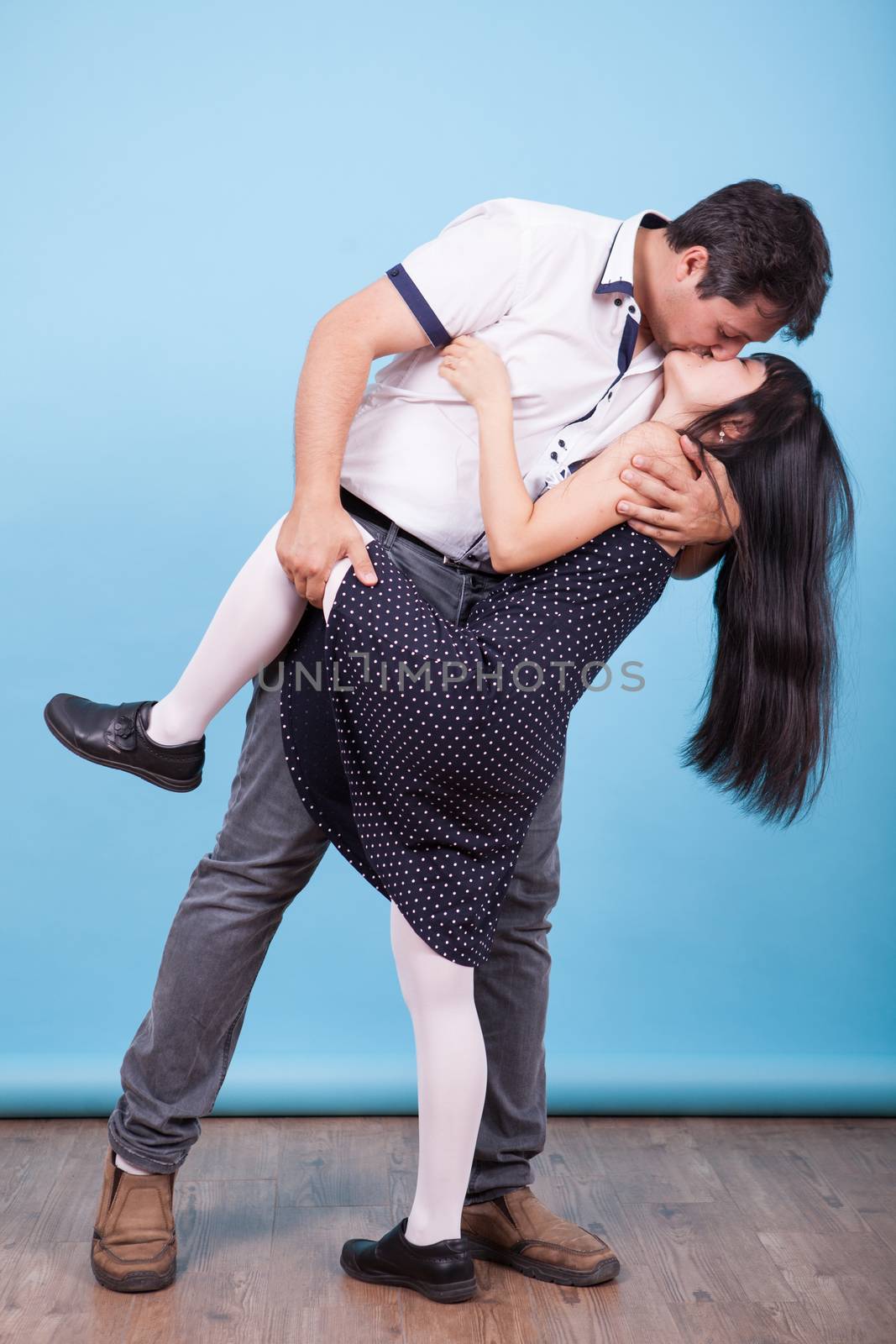 Caucasian boyfriend kissing and hugging his asian girlfriend in studio. Interracial couple.