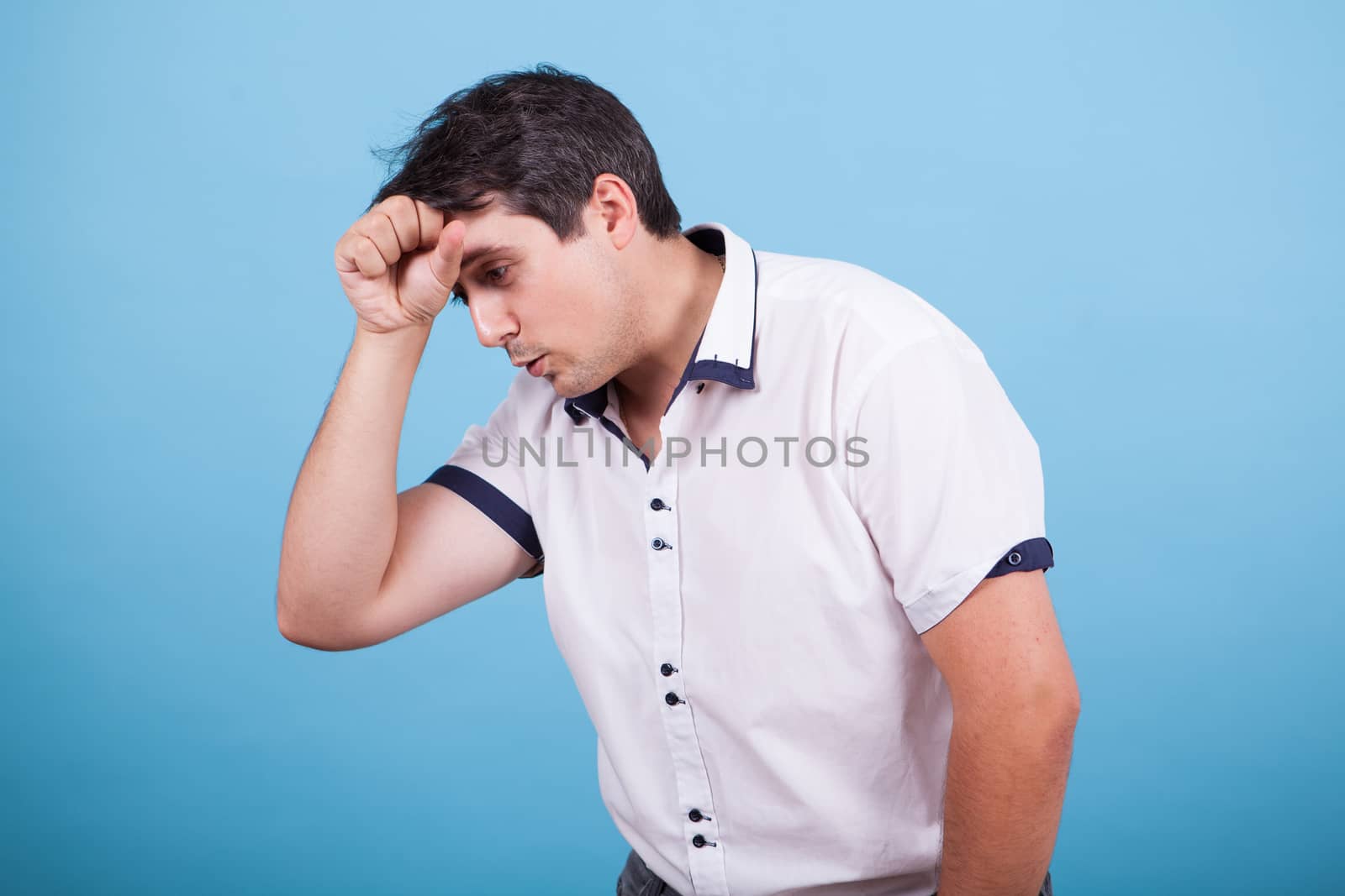 Caucasian thinking about a dilema with hand on his forehead. Hand gesture.