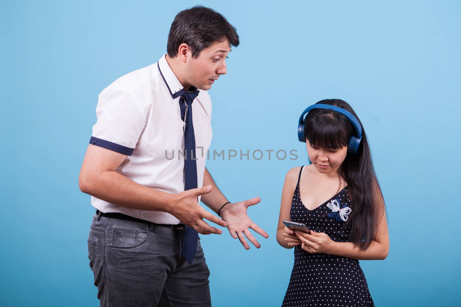 Asian girlfriend ignoring her caucasian boyfriend while he's trying to speak with her. Interracial couple.