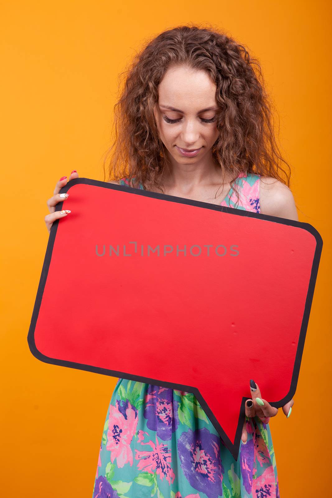 Portrait of young woman looking down on a empty placard. Copy space available.