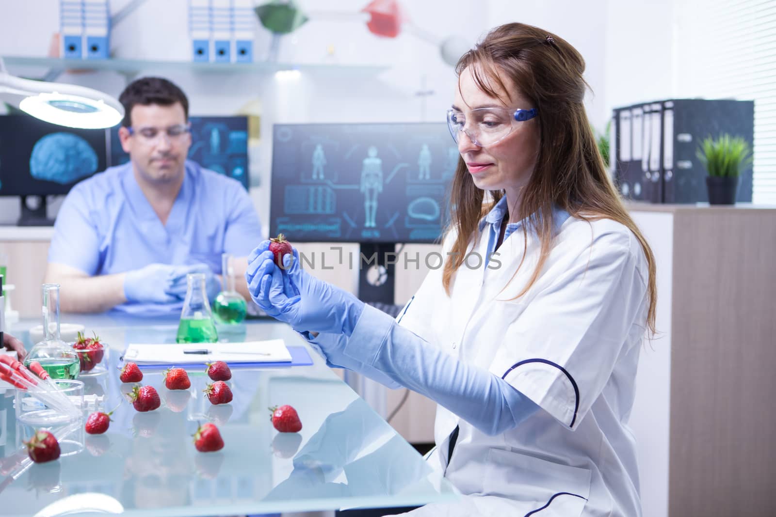 Female scientis with protection gear working in a microbiology research lab. Biologist in a research lab.