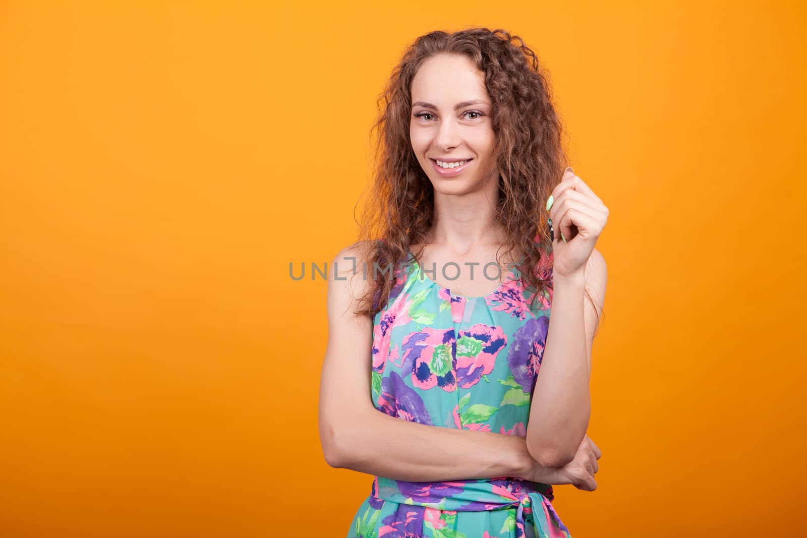 Portrait of confident woman posing with arms crossed in studio in beautiful dress.