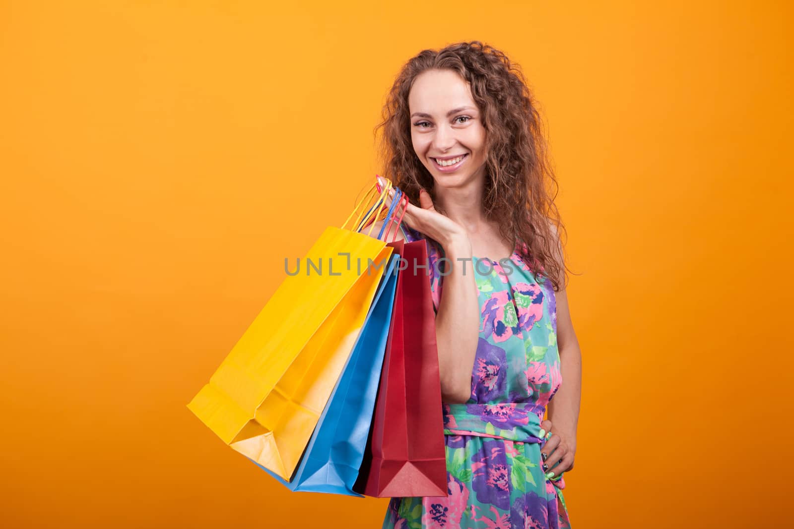 Attractive woman in pretty dress holding shopping bags. Fancy lifestyle.