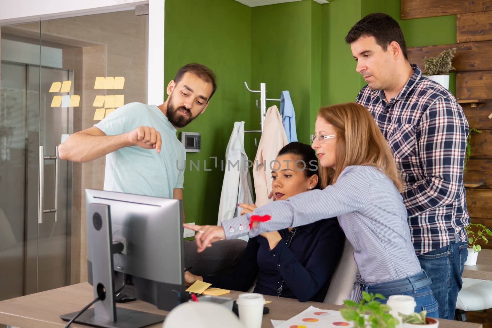Worker of start-up company having a discussion in front of computer screen