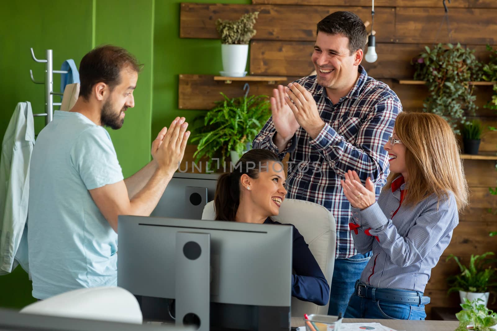 Business people in cozy office clapping at the success of new project. Teamwork and success