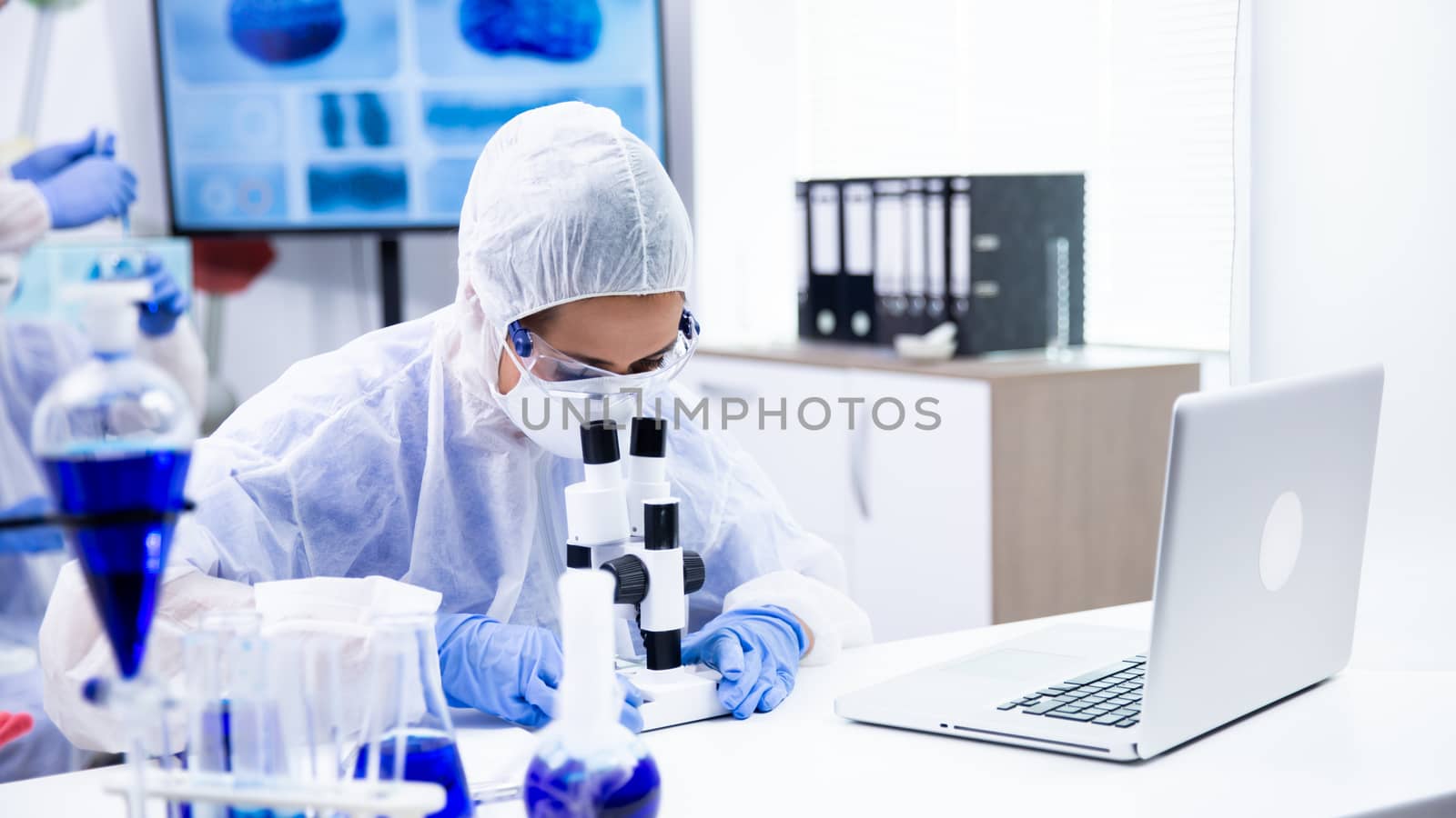 Caucasian chemist is watching a reaction under the microscope. Pharmaceutical research