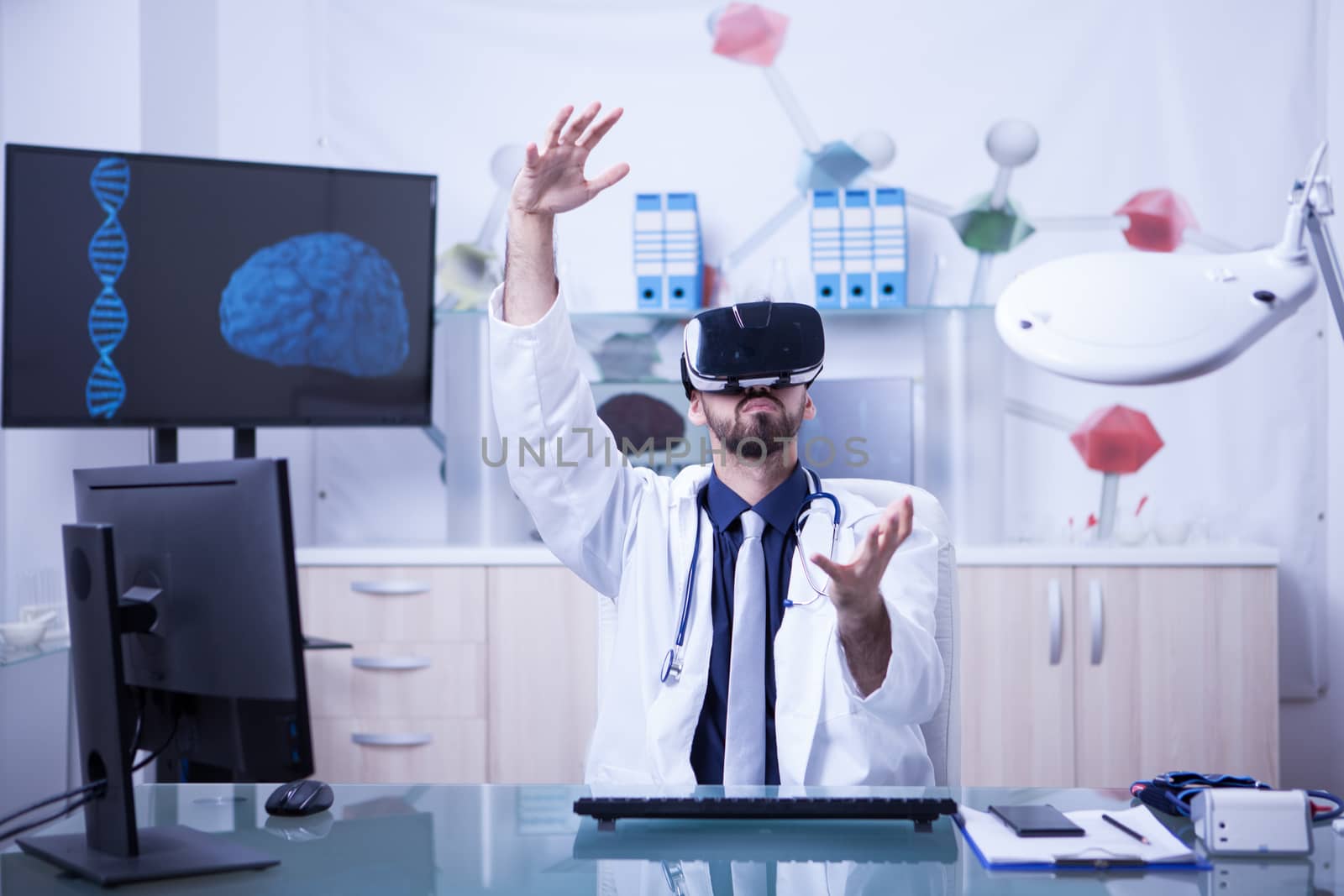 Young male doctor conducting medical procedure wearing virtual reality headset. New technology in medicine