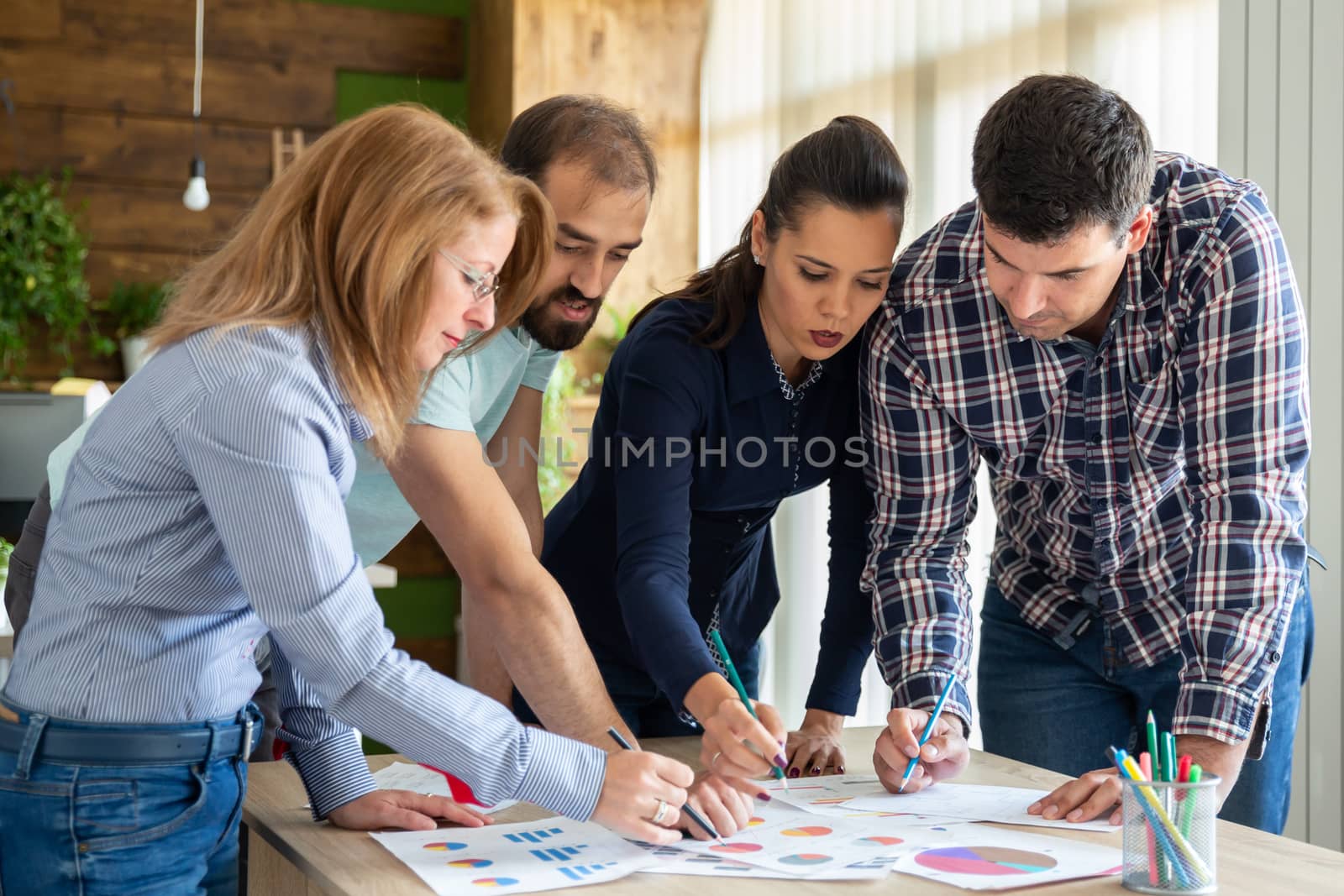 In creative company office employees preparing a new project. Caucasian young group