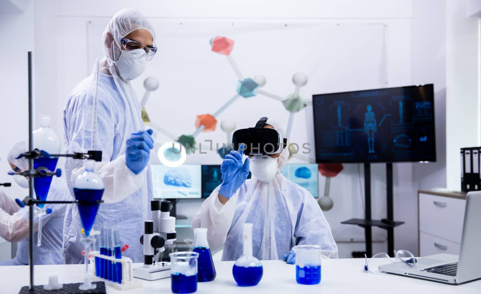 Chemistry scientist using virtual reality simualtion in modern laboratory. Scientific test tubes with smoking blue liquid.