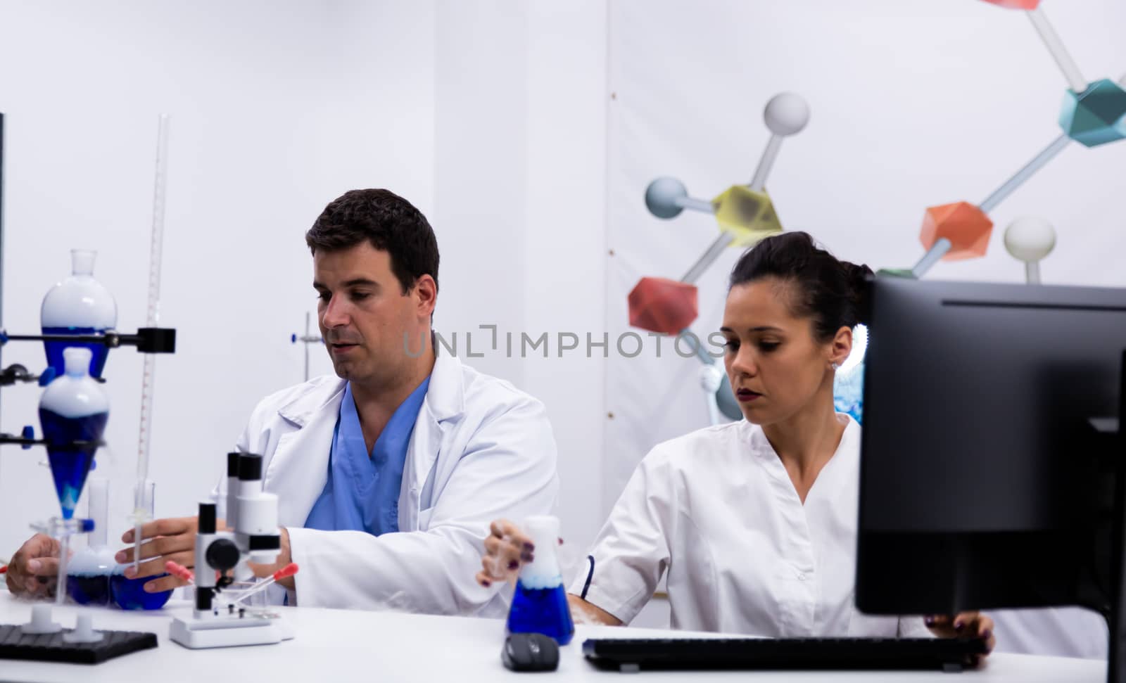 Team of researchers wearing coat in modern research laboratory. Pc in laboratory.