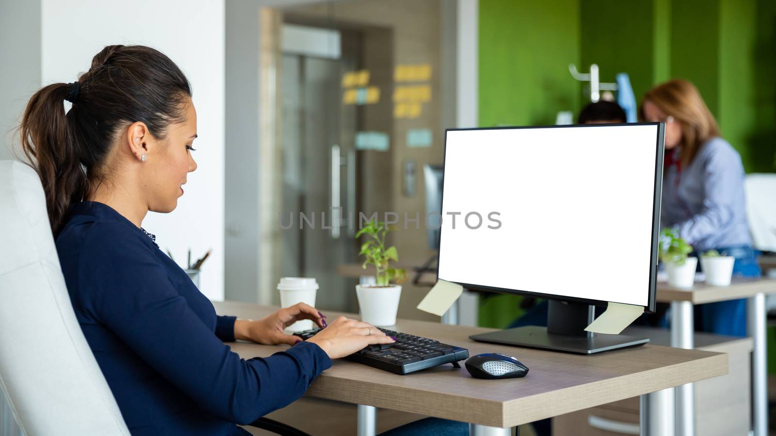 Worker from the start writing something on the computer and looking focused on the screen