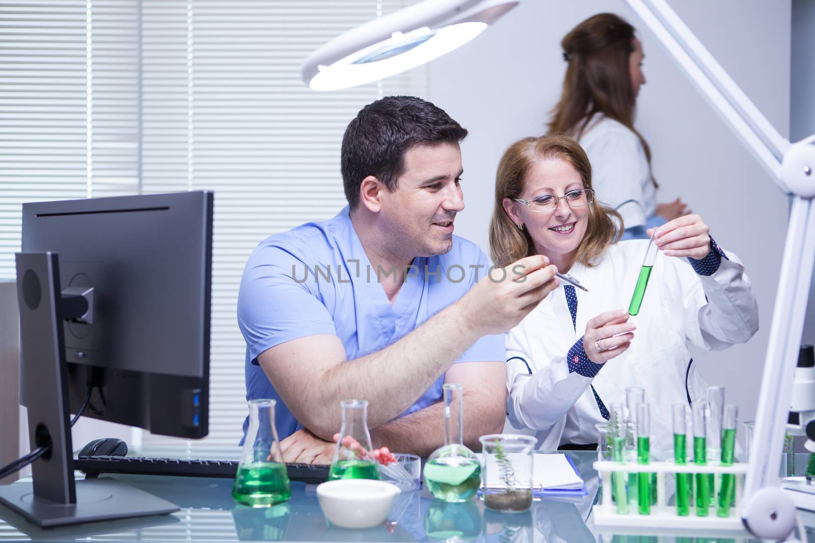 Team of advanced scientist checking the solution from a test tube in their laboratory. Research lab