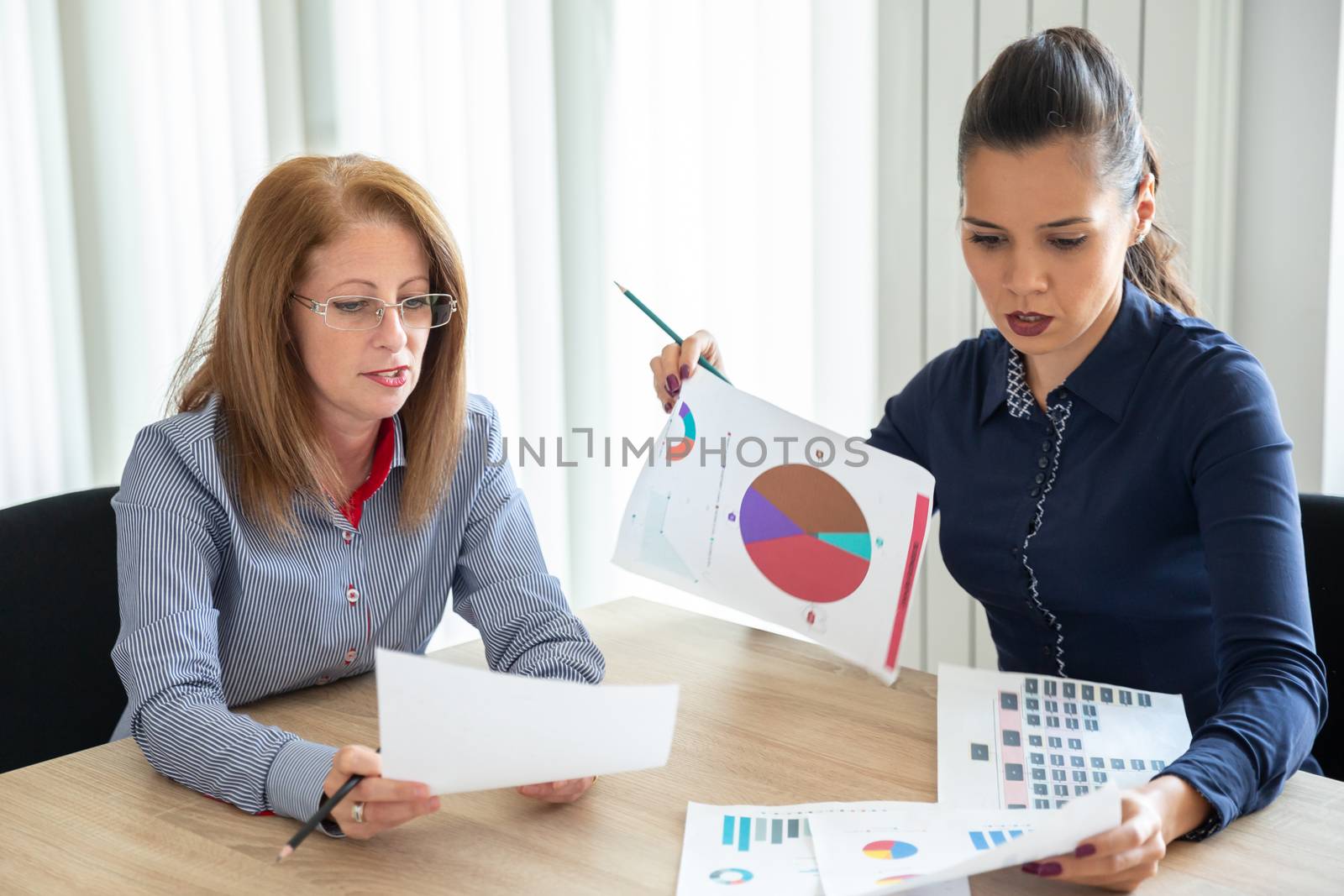 Two colleagues discuss the annual report. Office meeting