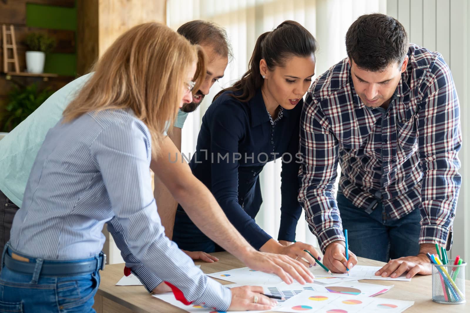 Young creative team in start-up company works at the table. Teamwork and meeting