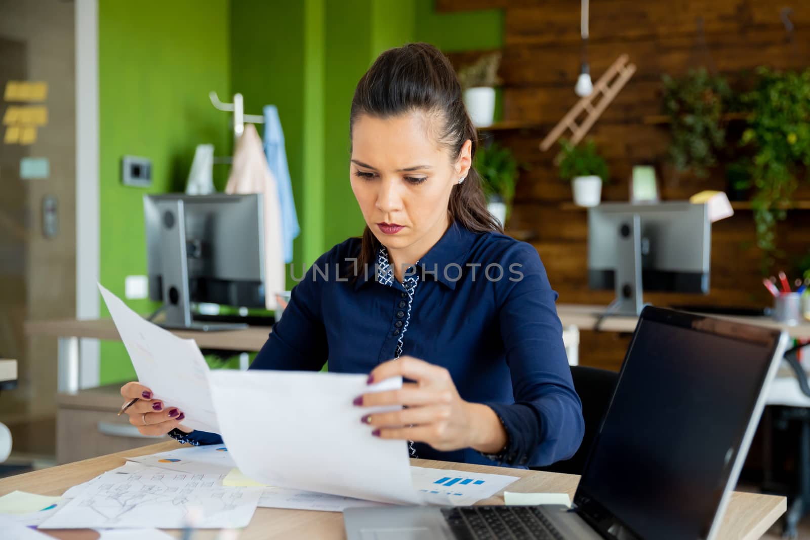 Start-up manager checking the annual report. Laptop screen and attractive office