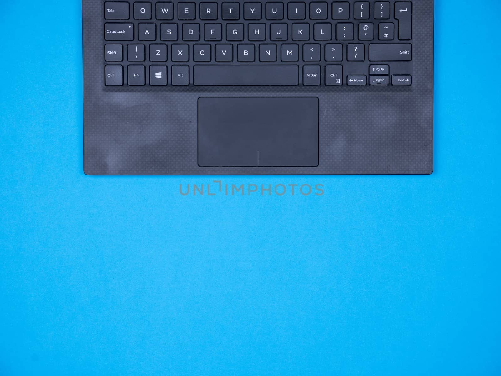 Flat lay top view of modern laptop over blue background. Copy space available.