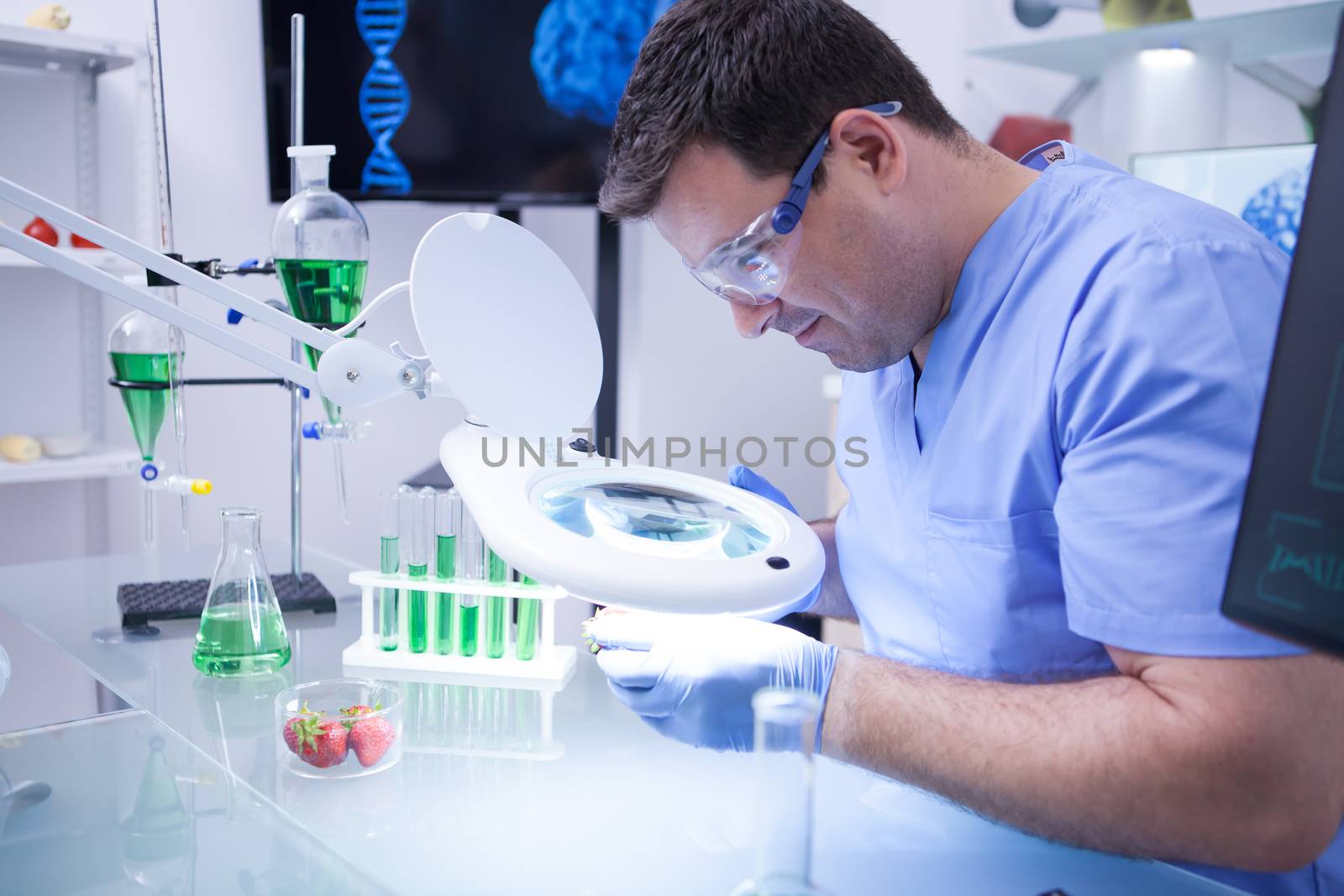Young scientist man wearing protection glasses in a research lab. Quality lab research.