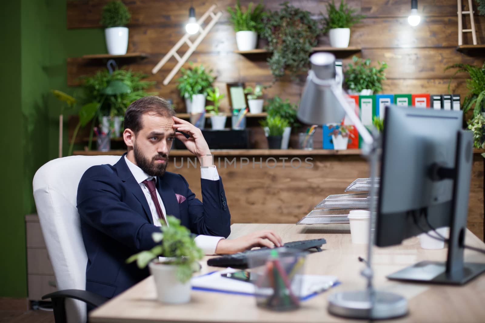 Portrait of bearded young entreprenur concentrating hard on the task. Confident analyst.