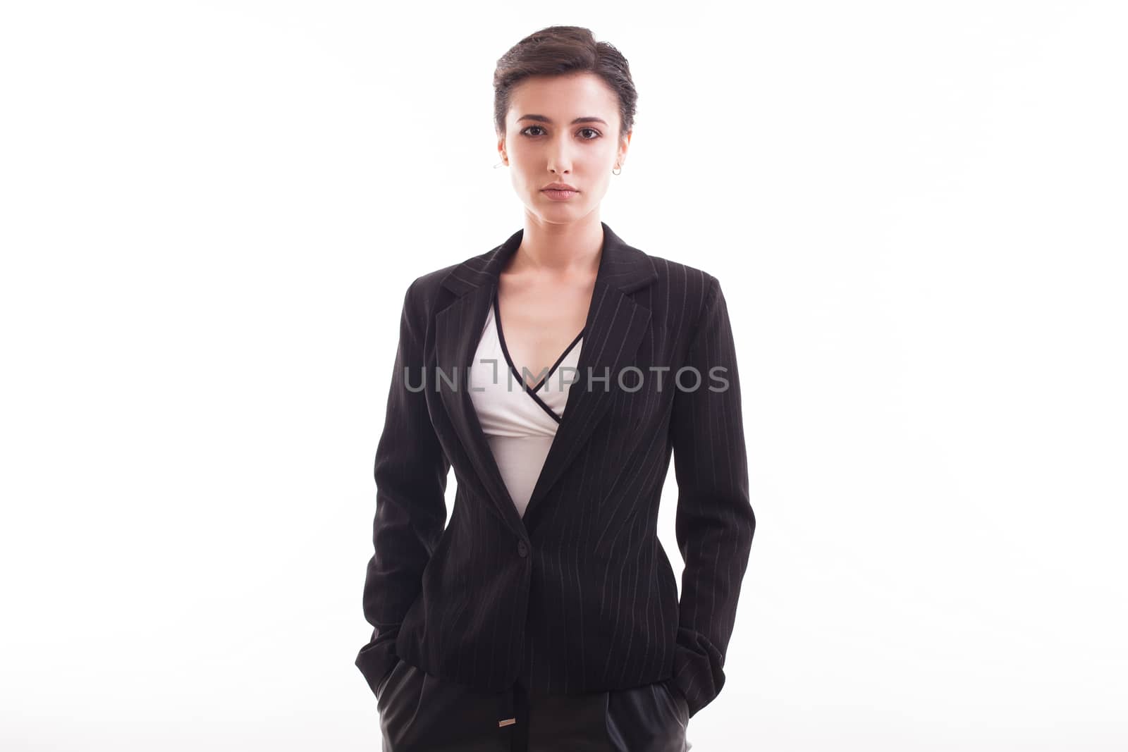 Attractive young girl looking at the camera wearing a black jacket over white background in studio. Stylish female.
