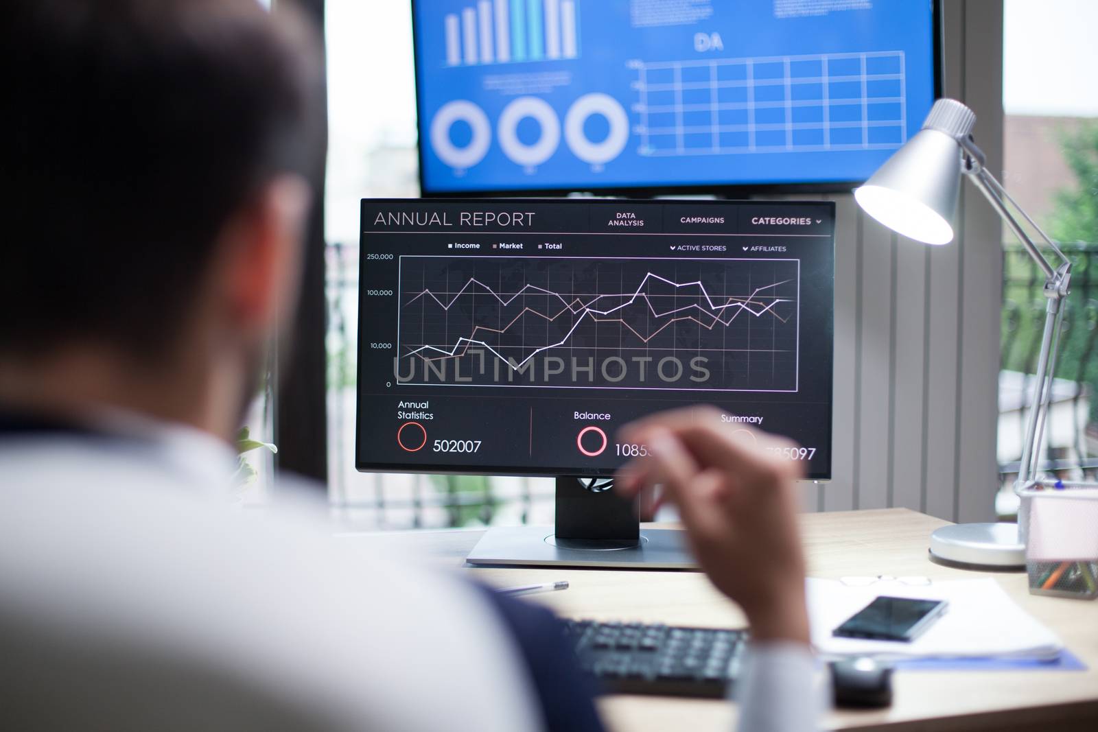Graphics displayed on computer monitor for professional analysis by business man. Entrepreneur in his office.