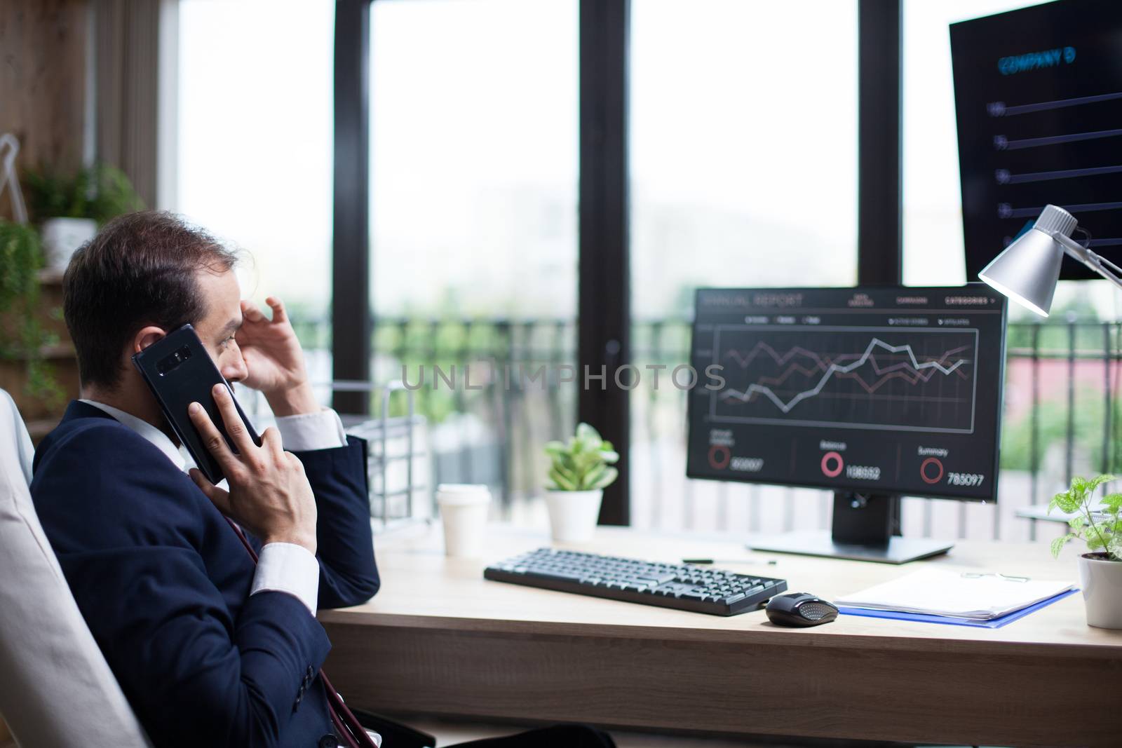 Side view of young business man talking on the phone and thinking about his marketing strategy. Intelligent businessman.