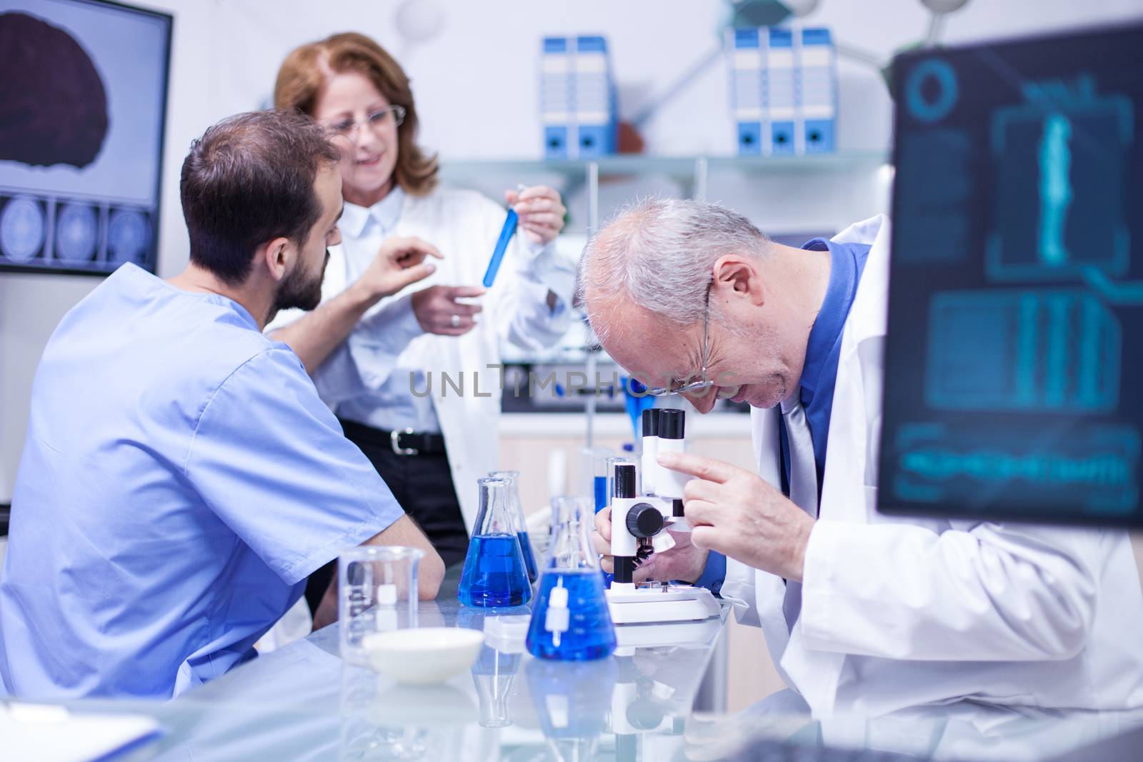 Senior scientist using a microscope in a hospital laboratory for research. Modern laboratory equipment.