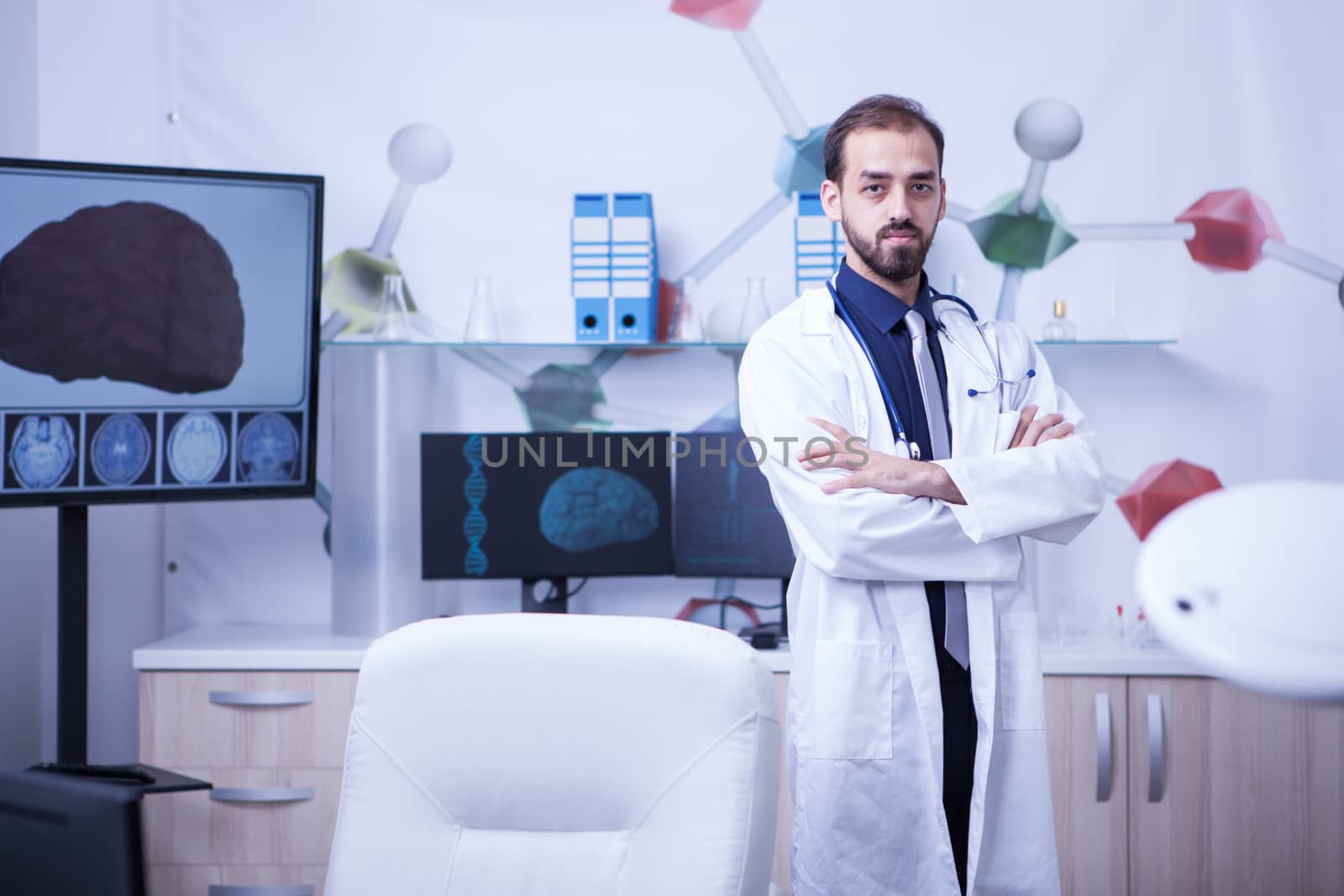 Full lenght portrait of young doctor with arms crossed looking at the camera. Young cardiologist.