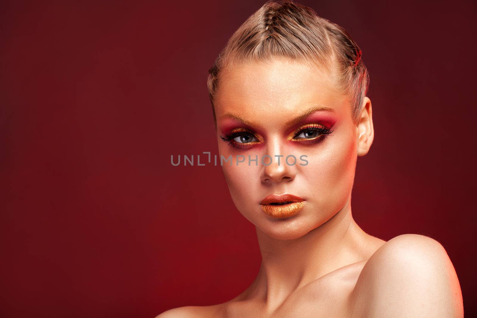 High Fashion model woman with stylish makeup on red background. Makeup trends. Golden eyebrows. Pink makeup. Beauty makeup. Beautiful woman.