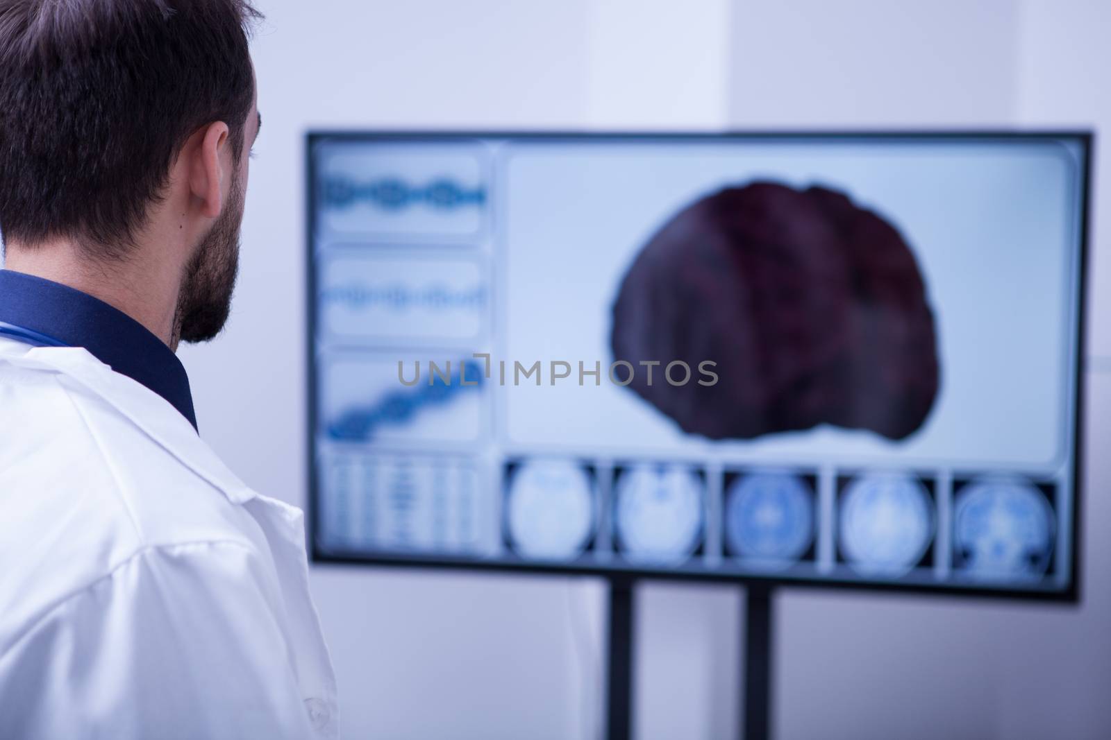 Young male surgeon using technology to check out a patient brain. Brain on the screen.