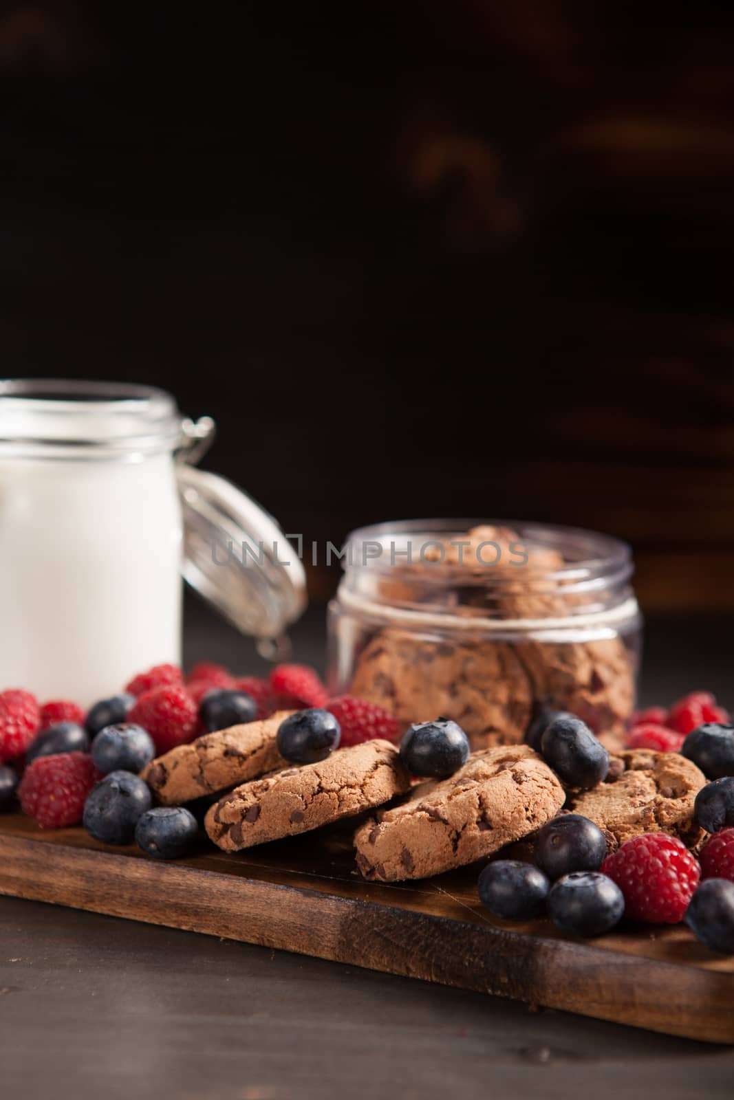 Breakfast ready to be served made out of tasty chocolate chips, milk and fresh bluebarries. Delicious cookies.