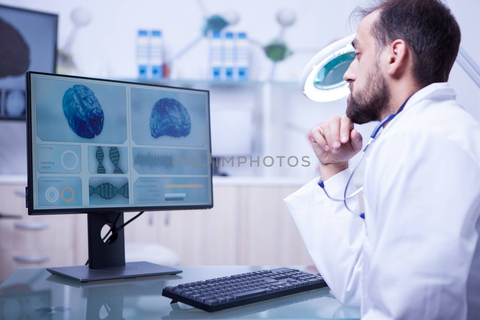 Young male doctor specialised in brain tumor checking a bran in hospital laboratory. Brain examination.