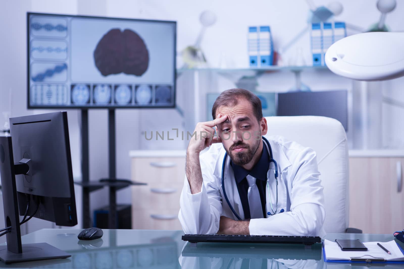 Portrait of young scientist overworked in the hospital laboratory. Doctor having a headache after a long day at the hospital.