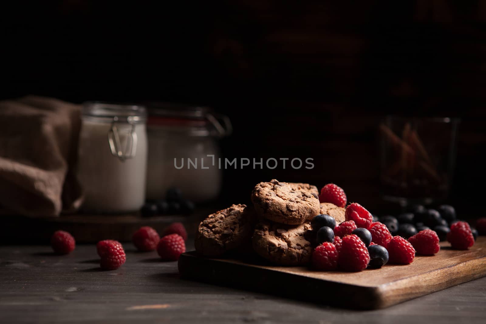 Delicious homemade cookies on wooden rustic plate. Tasty treat. Bottle of milk