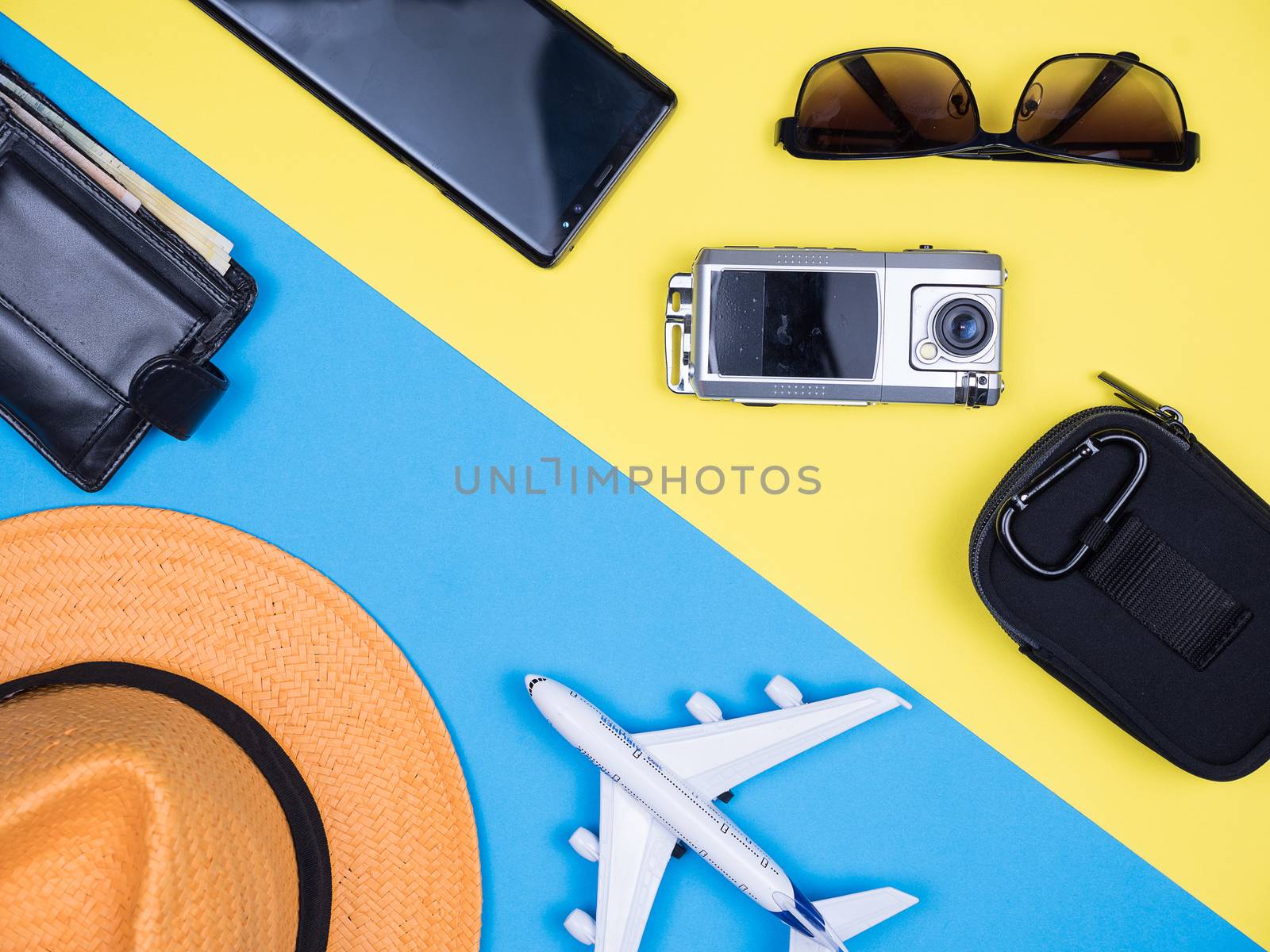 Flat lay top view of traveler kit for holiday over blue background. Traveler hat. Small traveler camera.